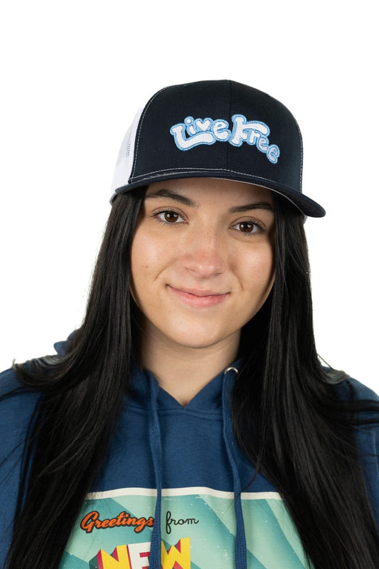Model wearing navy Live Free trucker embroidered hat featuring bold font and graphic design