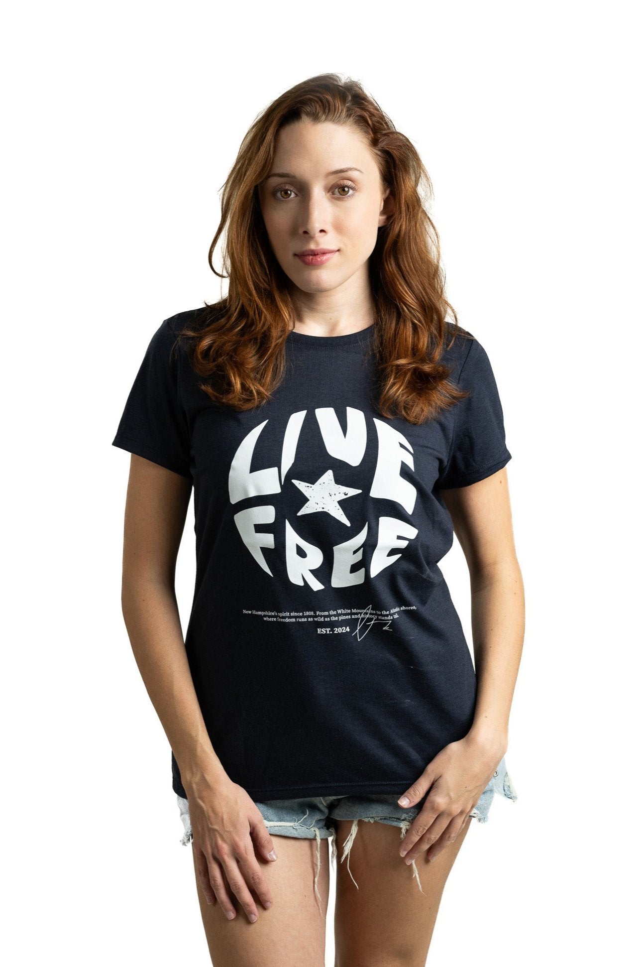 Model wearing navy blue Live Free women's graphic tee with bold design celebrating New Hampshire