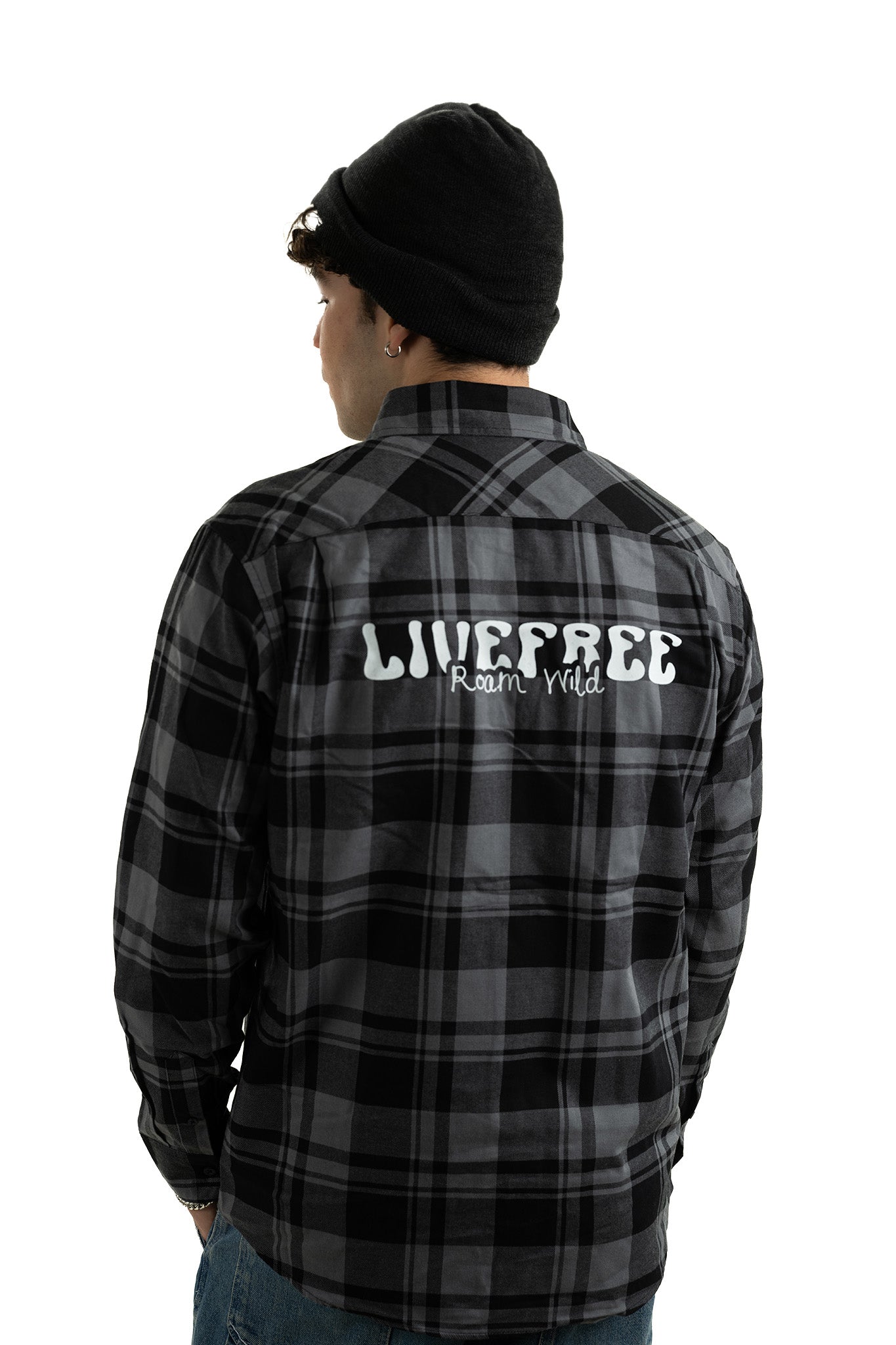 Young man in unisex Live Free plaid shirt NH featuring bold printed slogan on the back