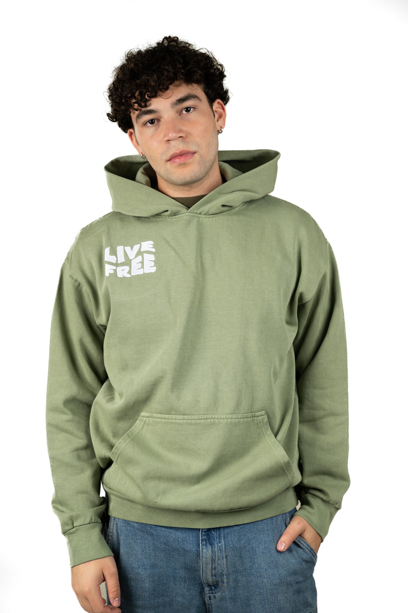 Young man wearing an sage green oversized hoodie from Live Free Clothing, standing casually with a relaxed fit and streetwear style