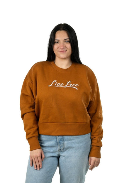 Model in clay women’s Live Free embroidered sweatshirt with flattering cropped fit and design